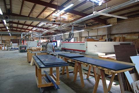 Plant staff working the beam saw.